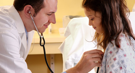 Doctor using a stethoscope on a little girl